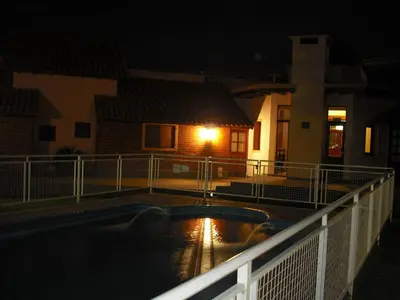 a swimming pool at night with a house at Hosteria Sueños Dorados in Merlo