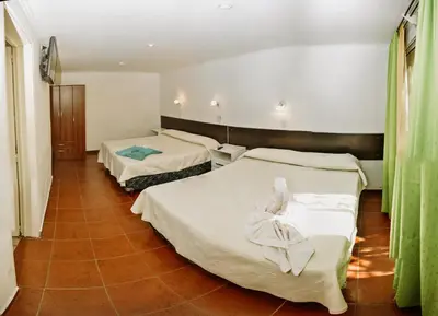 a hotel room with two beds with white sheets at La Candida Hotel in Merlo