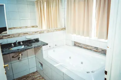 a bathroom with a tub and a sink at La Candida Hotel in Merlo