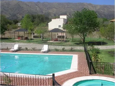 a swimming pool with two chairs and a house at La Candida Hotel in Merlo