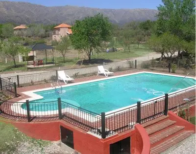 a large swimming pool with two lawn chairs at La Candida Hotel in Merlo
