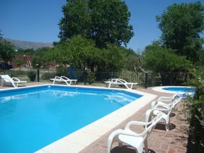 a swimming pool with white chairs next to it at La Candida Hotel in Merlo