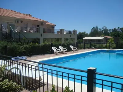 a swimming pool with two lawn chairs next to a house at La Candida Hotel in Merlo