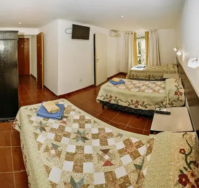a hotel room with two beds and a quilt on the floor at La Candida Hotel in Merlo