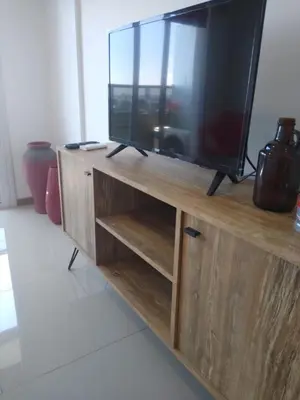 a television sitting on top of a wooden entertainment center at Dpto con pileta y cochera Güemes - Nueva Córdoba -Seguridad 24 hs Terraza y asadores!! Balcón Panorámico! in Cordoba