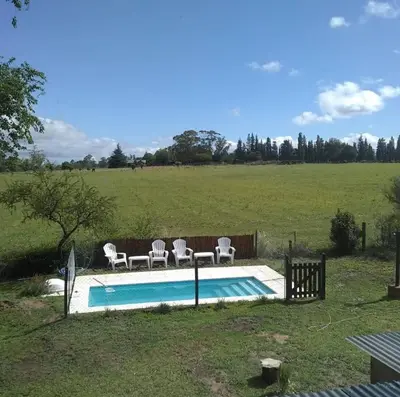 a pool with four chairs at Atardecer Serrano in Villa General Belgrano
