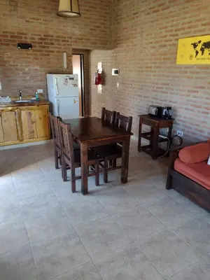 a kitchen with a table and chairs and a refrigerator at Atardecer Serrano in Villa General Belgrano