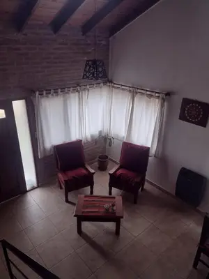 a living room with two chairs and a coffee table at Atardecer Serrano in Villa General Belgrano