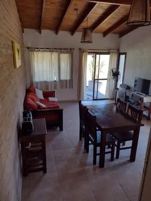 a living room with a table and a couch at Atardecer Serrano in Villa General Belgrano