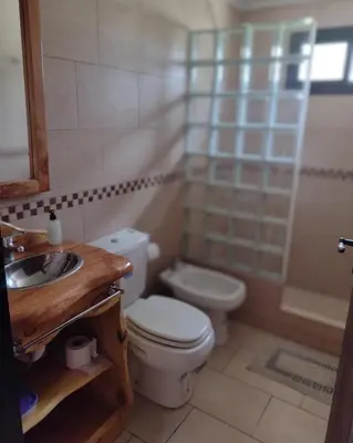 a bathroom with a toilet and a sink and a shower at Atardecer Serrano in Villa General Belgrano