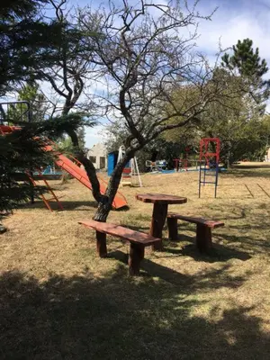 a picnic table and a tree in a park at Cabaña julian in La Cumbrecita