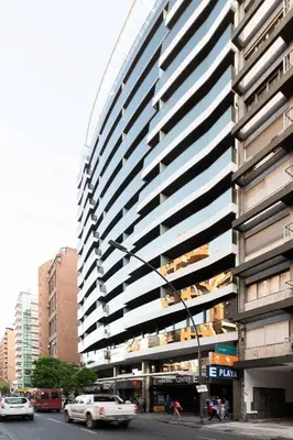 a tall building on a city street with cars at Departamentos Illia By Lugar in Cordoba