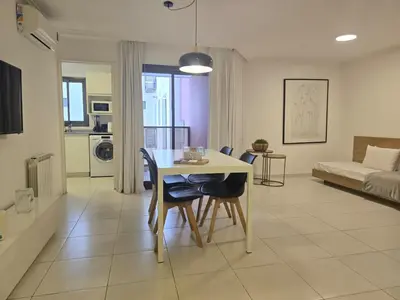a kitchen and living room with a table and chairs at Departamentos Illia By Lugar in Cordoba