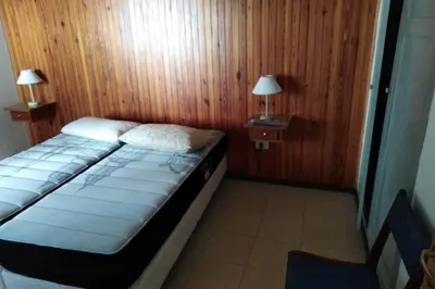 a bedroom with a bed in a room with wooden walls at Chalet interno con rooftop in Villa Carlos Paz