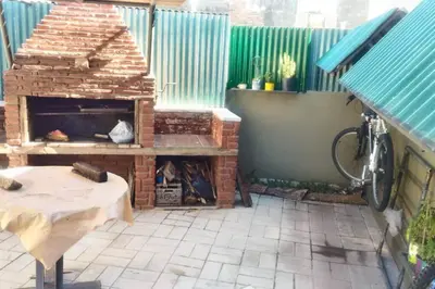 a patio with a brick fireplace and a table at Chalet interno con rooftop in Villa Carlos Paz