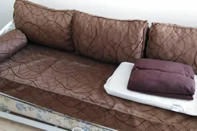 a brown couch with two pillows on it at Chalet interno con rooftop in Villa Carlos Paz