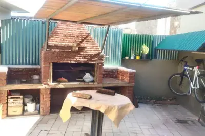 a brick pizza oven on a patio with a table at Chalet interno con rooftop in Villa Carlos Paz