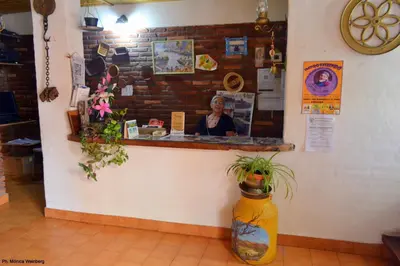 a counter in a store with a woman behind the counter at Hosteria de la Villa ** in Villa Cura Brochero