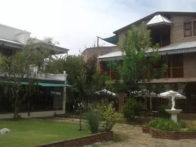 a building with a garden in front of it at Hostal Las Golondrinas in Bialet Massé