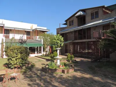 a courtyard of an old building with trees and plants at Hostal Las Golondrinas in Bialet Massé