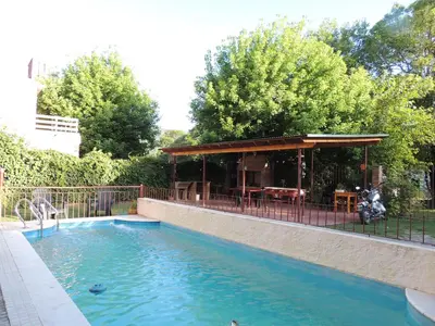 a swimming pool with a gazebo in a backyard at Hostal Las Golondrinas in Bialet Massé