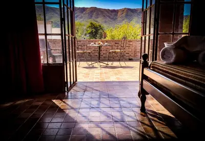 a room with a door open to a patio with a table at Hostal Las Golondrinas in Bialet Massé