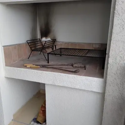 a room with a brick fireplace with a stove at Departamento Avani, nuevo A ESTRENAR, GIMNASIO Y SUM in Cordoba