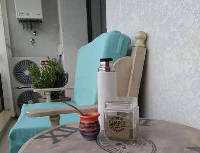 a table with a bottle of sauce and a blue chair at Departamento Avani, nuevo A ESTRENAR, GIMNASIO Y SUM in Cordoba
