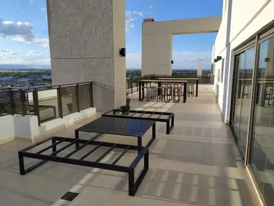 a balcony with benches and tables on a building at Departamento Avani, nuevo A ESTRENAR, GIMNASIO Y SUM in Cordoba