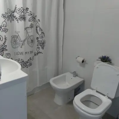 a bathroom with a toilet and a sink and a shower curtain at Departamento Avani, nuevo A ESTRENAR, GIMNASIO Y SUM in Cordoba