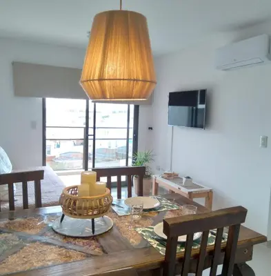 a dining room with a table and a lamp at Departamento Avani, nuevo A ESTRENAR, GIMNASIO Y SUM in Cordoba