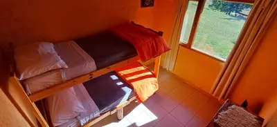 two bunk beds in a room with a window at Cabaña Esquina Siracusa in Villa Yacanto