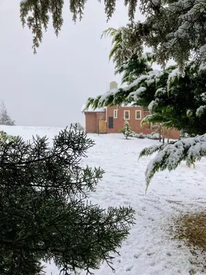 a snow covered yard with a building in the background at Cabaña Esquina Siracusa in Villa Yacanto