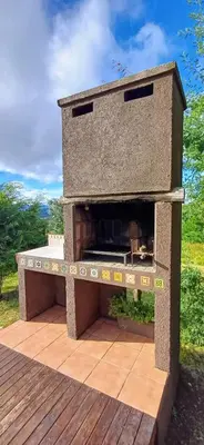 a stone pizza oven sitting on a wooden deck at Cabaña Esquina Siracusa in Villa Yacanto