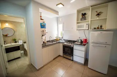 a kitchen with a white refrigerator and a sink at Río Cuarto Host in Río Cuarto