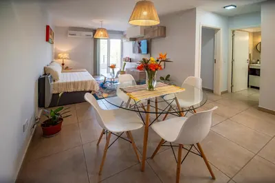 a dining room and living room with a table and chairs at Río Cuarto Host in Río Cuarto