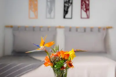 a vase with flowers and a bird on a table at Río Cuarto Host in Río Cuarto