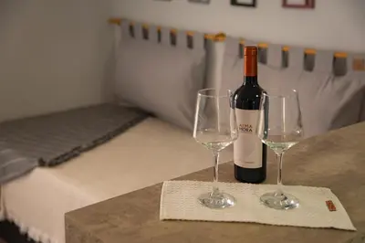 a bottle of wine and two wine glasses on a table at Río Cuarto Host in Río Cuarto