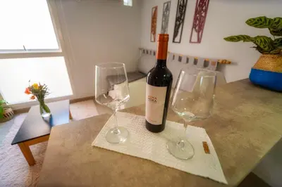 a bottle of wine sitting on a table with two wine glasses at Río Cuarto Host in Río Cuarto