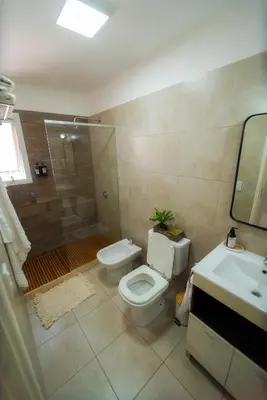 a bathroom with a toilet and a shower and a sink at Río Cuarto Host in Río Cuarto