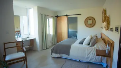 a bedroom with a bed and a desk and a bathroom at Amardecer - Casa Boutique in Merlo