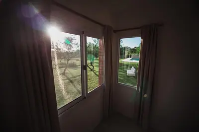 a room with two windows and a view of a yard at Amardecer - Casa Boutique in Merlo