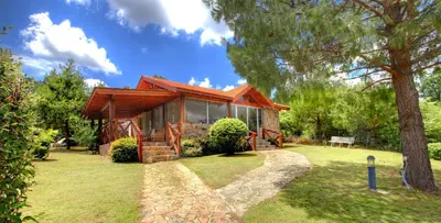 a house with a large window in a yard at Balcones de La Cumbrecita in La Cumbrecita