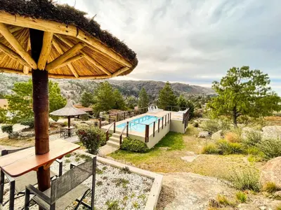 a house with a swimming pool and a large umbrella at Balcones de La Cumbrecita in La Cumbrecita