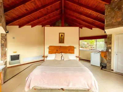 a bedroom with a large bed in a house at Balcones de La Cumbrecita in La Cumbrecita