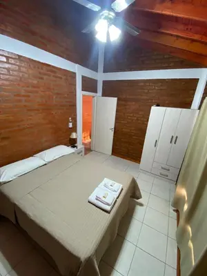 a bedroom with a bed and a brick wall at Nuova Costa Cabañas in Los Molles