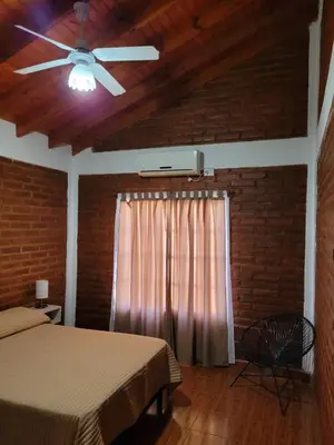 a bedroom with two beds and a ceiling fan at Nuova Costa Cabañas in Los Molles