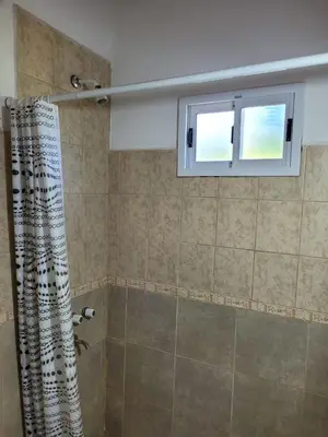 a bathroom with a shower with a window at Nuova Costa Cabañas in Los Molles