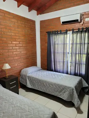 a bedroom with two beds and a window at Nuova Costa Cabañas in Los Molles