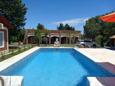 a swimming pool in front of a house at Nuova Costa Cabañas in Los Molles
